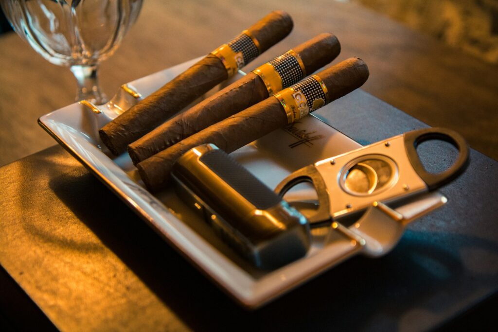 Photo by Yohan Cho three cigar beside cutter on ashtray